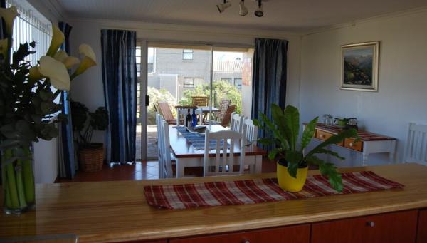 Open-plan kitchen with spacious dining area next to outdoor braai. 