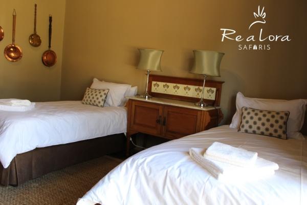 Re a Lora Lodge bedroom with twin beds and private bathroom